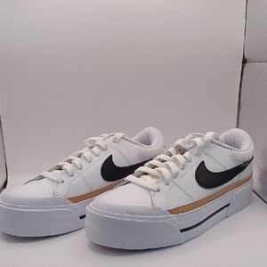Nike Women's White Sneakers with Black Swoosh and Gold Stripe